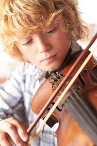 在家里拉小提琴的小男孩