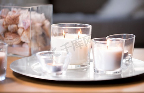 元宵遇上情人摄影照片_装饰，hygge和舒适的概念—燃烧白色香味蜡烛在托盘在桌子上。燃烧白色香味蜡烛在托盘在桌子上