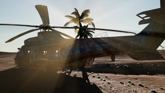 军事领域摄影照片_日落时分，一架破旧的军用直升机在沙漠中