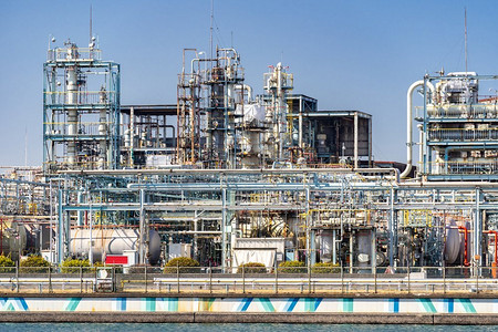 工业烟囱摄影照片_化工厂工厂与气体存储和管道结构与烟囱烟雾在川崎市附近的日本东京