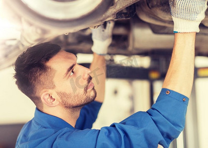 汽车维修，维修，保养和人员概念—汽车修理工或铁匠在车间工作。在车间修理汽车的机修工或铁匠