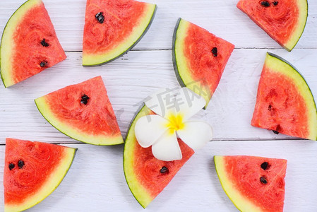 新鲜的西瓜切片纹理背景/西瓜无缝的夏天水果和白色的花，顶视图