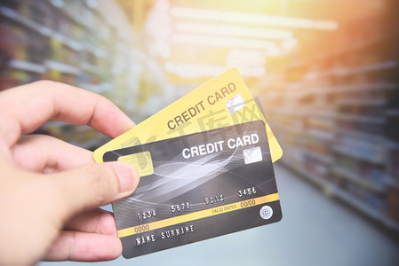推车购物摄影照片_信用卡在超市购物/手持信用卡付款 