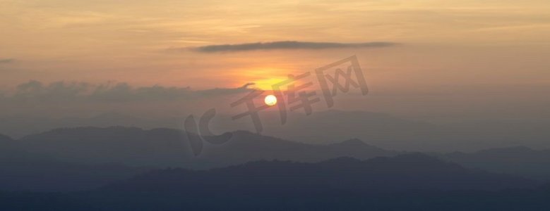 落山的太阳摄影照片_太阳落山时的山景。