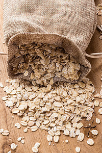 节食。燕麦谷物在粗麻布袋在木表面上。降胆固醇、保护心脏的健康食品。