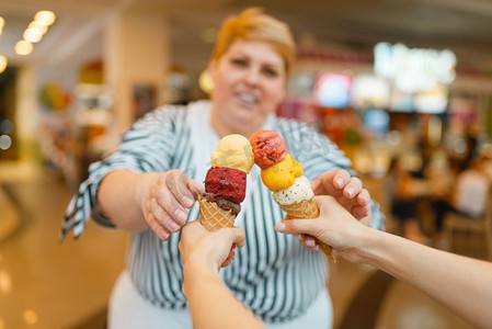肥胖女性摄影照片_胖女人在快餐店买两个冰淇淋。超重女性吃冰淇淋，肥胖问题