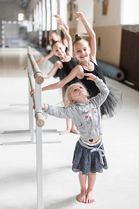 可爱的女孩练习芭蕾舞与她的妹妹舞蹈工作室