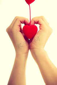 爱和帮助。光滑的女性手，象征着慈善和喜爱。带着红色小心的手掌..女性的手和小心脏。