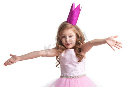 孩子的困惑摄影照片_美丽的小公主女孩戴着王冠，双手举在空中说，为什么，我不知道，那又怎样。小公主