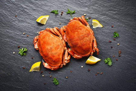 蟹与柠檬在盘子上服务在黑暗板顶视图/石蟹蒸海鲜 