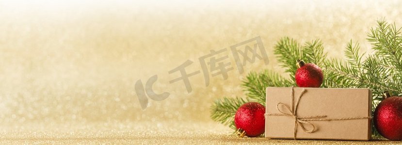 圣诞节玩具，装饰品，礼物盒包装在牛皮纸在金色闪光背景，复制空间。圣诞礼品盒和装饰