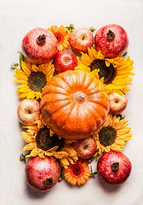 南瓜与苹果，花，石榴和向日葵在白色桌子，顶视图.秋季或夏末布局作曲。感恩节安排