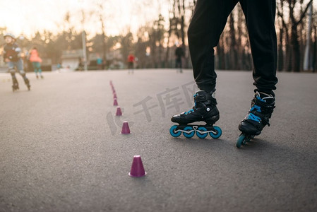 溜冰鞋的腿在柏油人行道在城市公园。休闲男子轮滑