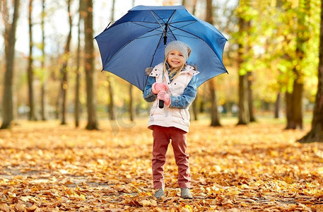 孩子伞摄影照片_童年，季节和天气概念—快乐的小女孩与伞在秋天公园。快乐的小女孩与伞在秋天公园
