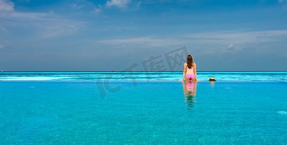妇女放松在无限泳池在马尔代夫