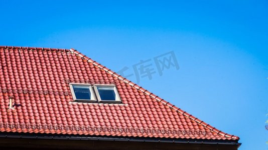 极简红色摄影照片_屋顶极简射击与红色瓷砖在明确的蓝天背景极简拍摄的红色屋顶在蓝天