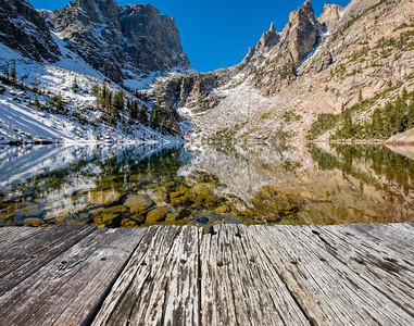 秋天，翡翠湖和倒影与岩石和群山在雪中环绕。美国科罗拉多州落基山国家公园。