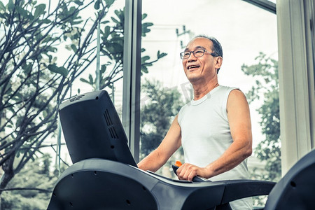 老年人在健身中心的跑步机上锻炼。成熟健康的生活方式..老年人在健身中心的跑步机上锻炼