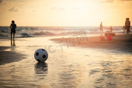 沙滩背景摄影照片_沙滩上的足球/在海滩上踢足球日落的大海背景