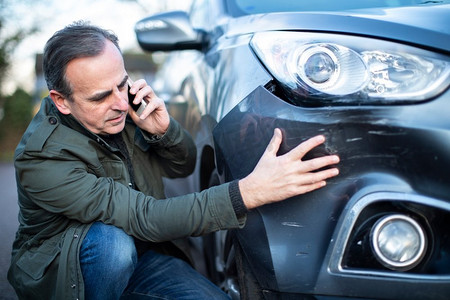 车祸后不高兴的成年男性车祸司机打电话给保险公司