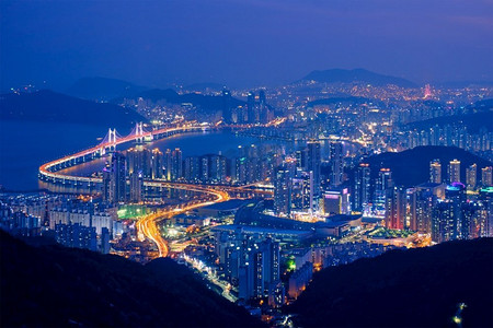 釜山的城市景观与摩天大楼和光岸大桥在晚上照明。釜山韩国釜山城市景观光岸大桥在晚上
