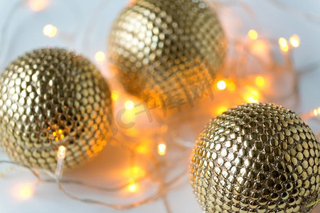 装饰、假日和奢华概念-金色圣诞球和花环彩灯。金色圣诞球和花环彩灯