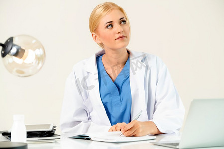 健康报告摄影照片_医院或保健机构的女医生在办公室桌子上做医疗报告。医院里的医生在写医疗报告。