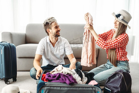 男人和女人收拾行李度假。旅行概念费。行李准备。男人和女人打包他们的行李箱度假