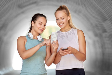 健身、运动和健康的生活方式理念-微笑的年轻女性或智能手机的女性朋友。拥有智能手机的女性或女性朋友
