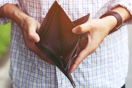 星空山川背景摄影照片_一个人拿着一个空钱包在一个人的手中没有钱从口袋里出来。金融储蓄观念	