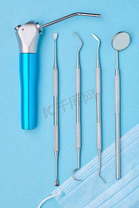 在浅蓝色背景顶视图平躺牙医工具。牙齿护理，牙齿卫生和健康概念。 