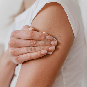 侧视图妇女在接种疫苗后抱着她的手臂