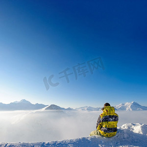 高山冬季山风景与人坐在低云之上。法国阿尔卑斯山在晴天被雪覆盖。Val—d Isere’