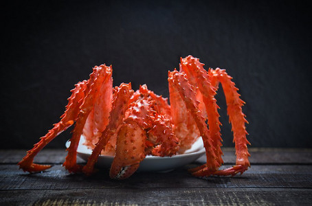 蟹菜摄影照片_帝王蟹蒸熟食物盘中深色海鲜/红阿拉斯加蟹北海道