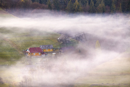 美丽的春光。传统的山上山村。乌克兰喀尔巴鄂的乡村日出。从房子里冒出来的烟。云雾缭绕。
