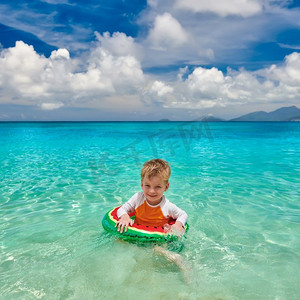三岁的蹒跚学步的男孩在塞舌尔游泳与充气环