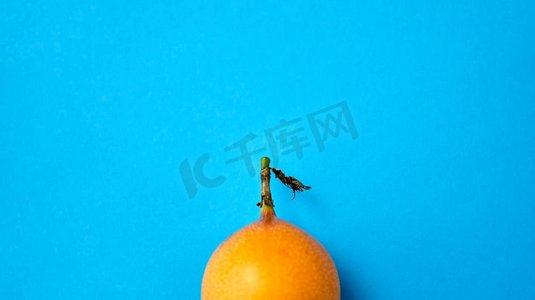 水果，饮食和食物概念—关闭成熟的格兰纳迪拉在蓝色背景。关闭granadilla在蓝色背景