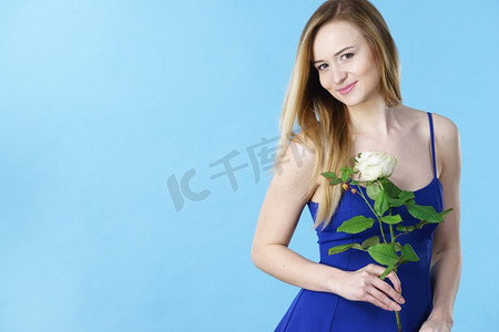 有吸引力的金发女郎拿着白色玫瑰花。情人节和妇女节礼物概念。可爱的女人拿着白玫瑰