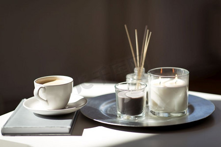 水疗和芳香疗法的概念-咖啡、蜡烛、书籍和桌子上的香草扩散器。桌子上有咖啡、蜡烛和香料扩散器