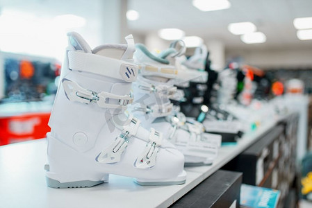 一排滑雪靴和滑雪靴在体育用品店，特写镜头，没有人。冬季极限，积极休闲，展示与保护设备