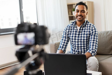 博客，videoblog和人的概念—印度男性博客与相机录制视频在家里。男性博客与相机videobblogging在家里