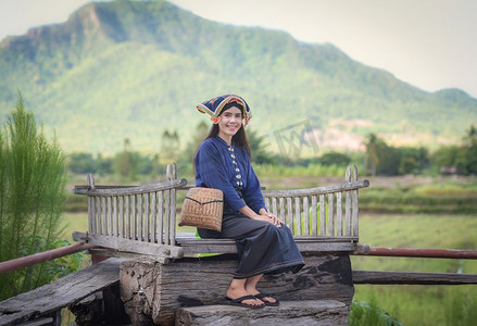 亚洲妇女泰国风格服饰部落Tai Dam/美丽的年轻女孩的画象微笑的泰国传统服装穿着与织物编织在头上 