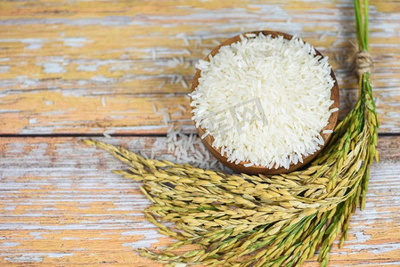 生茉莉花米粒与水稻农产品的穗食物在亚洲/泰国米白色在碗和木背景