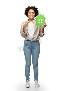 生态生活、环境和可持续发展理念--幸福的微笑着的女人在白色背景下拿着绿色的房子。微笑的女人捧着绿色的房子