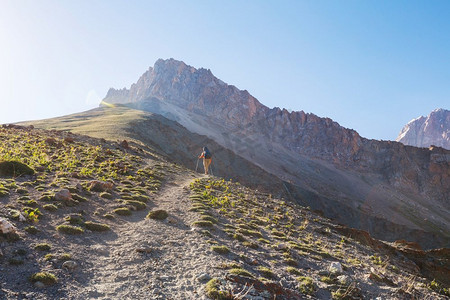 流浪癖时间。男子徒步旅行在美丽的范恩山在帕米尔，塔吉克斯坦。中亚