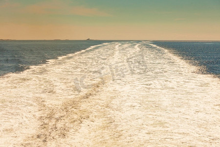 翻腾摄影照片_海和kielwater从船上看到，渡船帆后的水面上的踪迹，船的尾。渡船航行后的水上小径