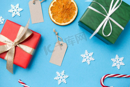 收藏本店标签摄影照片_冬季假期，新年和圣诞节概念—礼品盒，标签和装饰品在蓝色背景。圣诞礼物、标签和装饰品