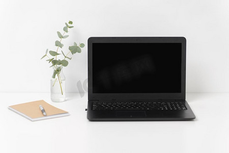 商务、电子和室内概念-白色办公桌上有黑色屏幕的笔记本电脑。白色办公桌上的黑屏笔记本电脑