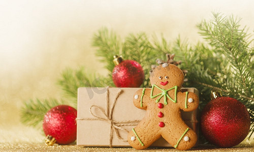 金色闪光摄影照片_圣诞节玩具，装饰品，礼物盒包装在牛皮纸在金色闪光背景，复制空间。圣诞礼品盒和装饰