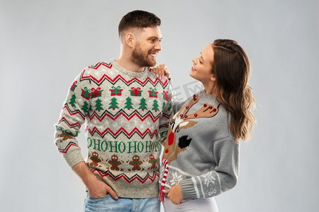 圣诞节，人和假日概念—在丑陋的毛衣党的幸福夫妇肖像。快乐的夫妇在圣诞节丑陋的毛衣党